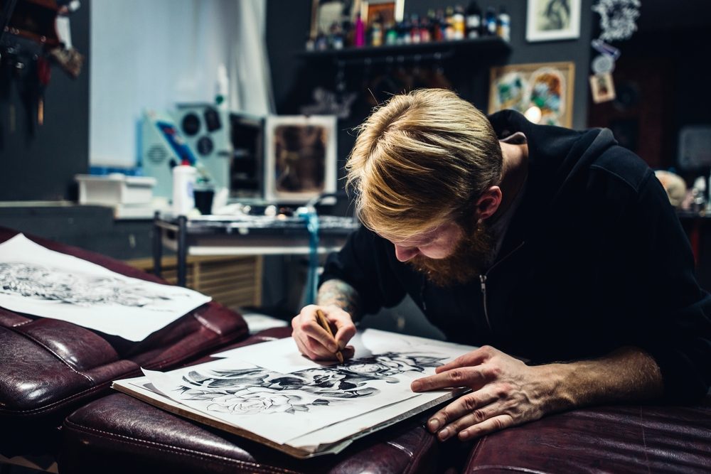Bearded man sketching at a desk — hypnotherapy case study of an artist who reopened his creative channel
