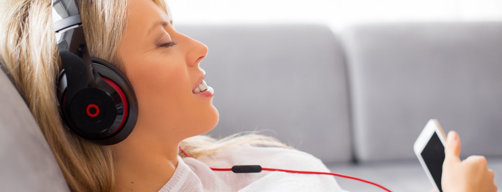 Woman relaxing with eyes closed and headphones during an online hypnotherapy session